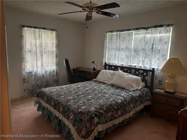 bedroom with ceiling fan, a textured ceiling, and carpet flooring