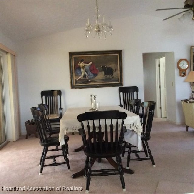 dining space featuring ceiling fan with notable chandelier, carpet floors, and lofted ceiling