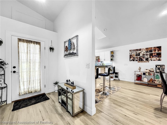 entrance foyer featuring light hardwood / wood-style floors and vaulted ceiling