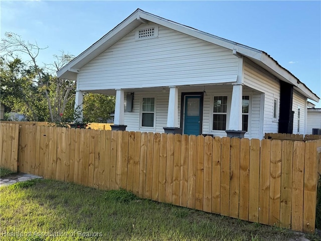 bungalow with covered porch and a fenced front yard