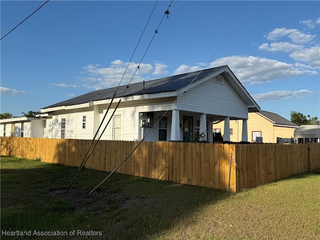 view of side of property featuring a lawn and a fenced front yard