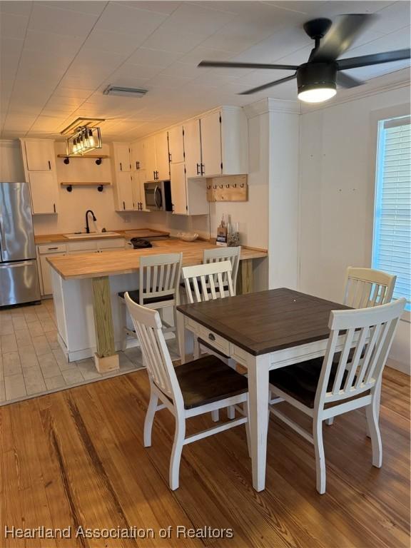 dining room featuring visible vents, ceiling fan, and light wood-style floors