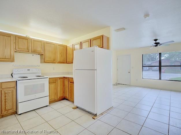 1916 Melady Ave, Sebring, FL 33870 - kitchen featuring white appliances, light countertops, a ceiling fan, and light tile patterned floors