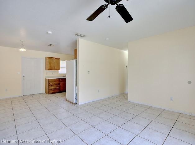 1916 Melady Ave, Sebring, FL 33870 - unfurnished living room featuring ceiling fan and light tile patterned floors