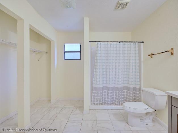 1916 Melady Ave, Sebring, FL 33870 - bathroom with vanity, a shower with curtain, a spacious closet, and marble look tiles