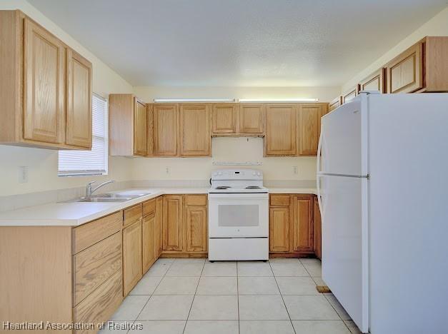 1916 Melady Ave, Sebring, FL 33870 - kitchen with white appliances, light tile patterned flooring, and light countertops