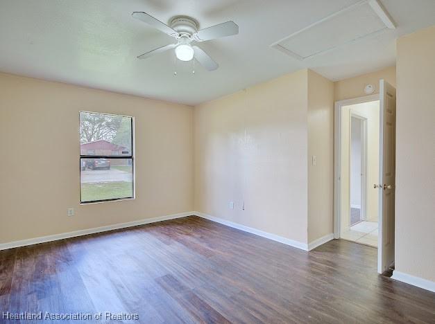 1916 Melady Ave, Sebring, FL 33870 - unfurnished room featuring dark wood-style flooring, ceiling fan, and attic access