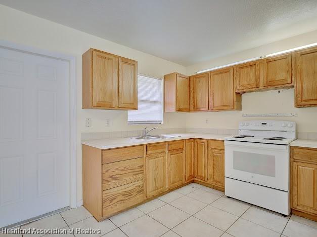 1916 Melady Ave, Sebring, FL 33870 - kitchen featuring white electric stove, light countertops, and light tile patterned flooring
