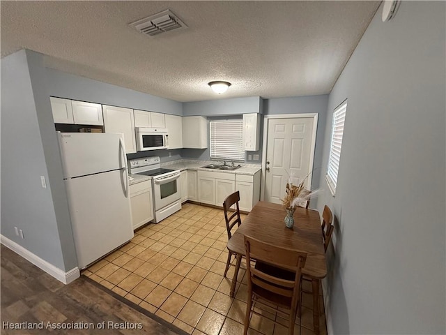 kitchen featuring white cabinetry, sink, white appliances, and a textured ceiling