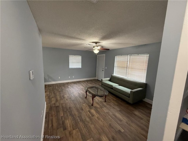 unfurnished living room featuring dark hardwood / wood-style floors, a textured ceiling, and ceiling fan