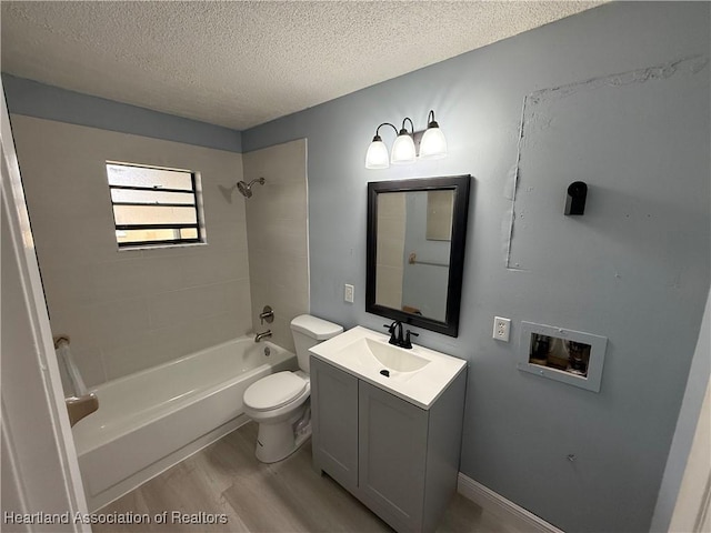 full bathroom featuring toilet, a textured ceiling, vanity, tiled shower / bath combo, and hardwood / wood-style floors