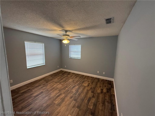 empty room with ceiling fan, a textured ceiling, and dark hardwood / wood-style flooring