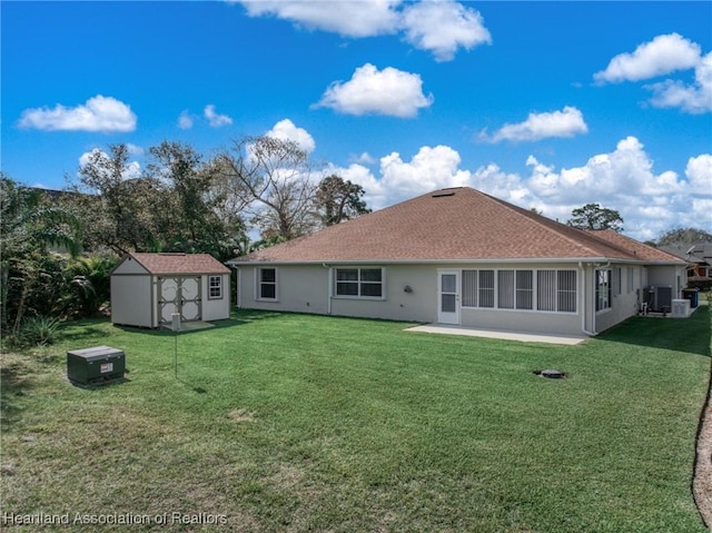 rear view of house with a yard, a patio area, central air condition unit, and a shed