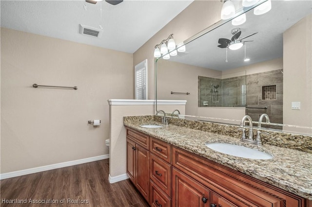 bathroom featuring vanity, wood-type flooring, toilet, and ceiling fan