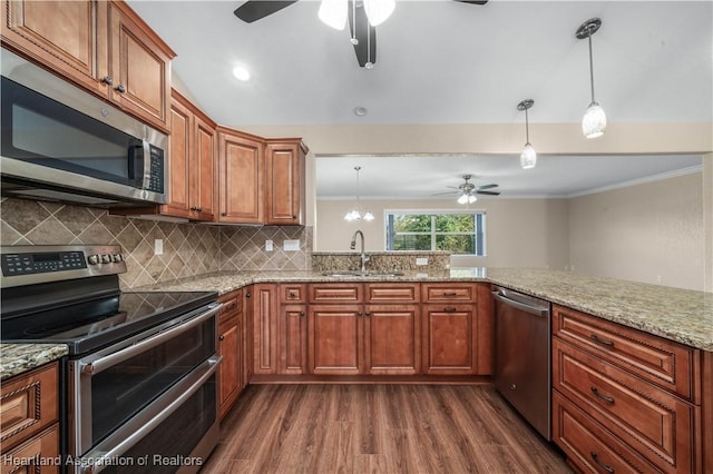 kitchen featuring stainless steel appliances, sink, pendant lighting, and kitchen peninsula