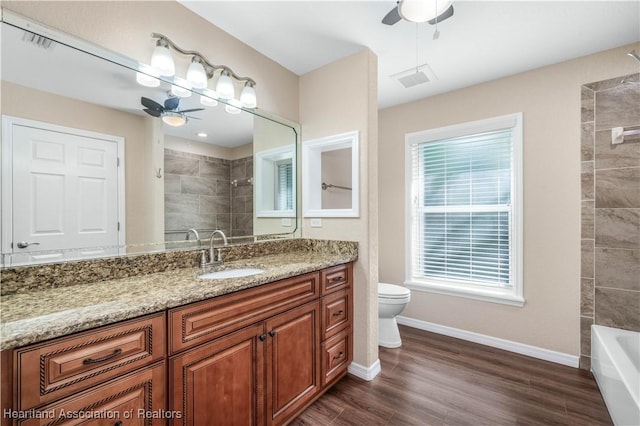 bathroom with vanity, hardwood / wood-style floors, ceiling fan, and toilet