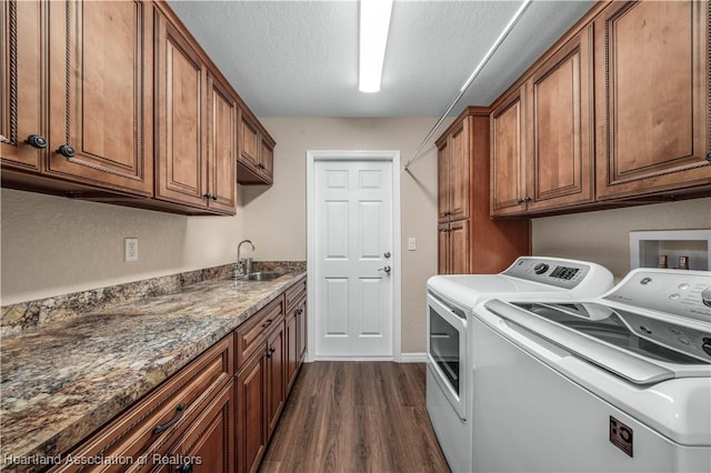 clothes washing area featuring dark hardwood / wood-style floors, cabinets, sink, and washing machine and dryer