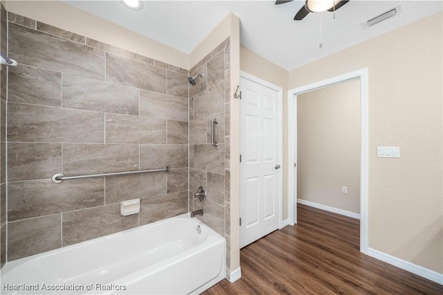 bathroom with tiled shower / bath combo, hardwood / wood-style flooring, and ceiling fan