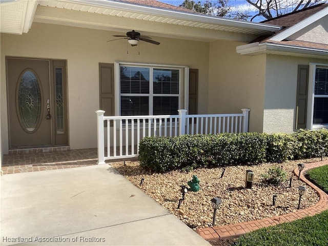 doorway to property featuring ceiling fan and a porch