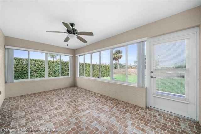 unfurnished sunroom featuring ceiling fan