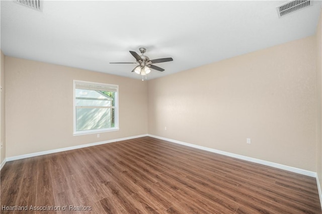 spare room featuring dark wood-type flooring and ceiling fan