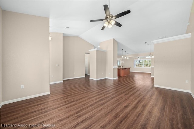 unfurnished living room with ceiling fan with notable chandelier, dark hardwood / wood-style floors, and vaulted ceiling