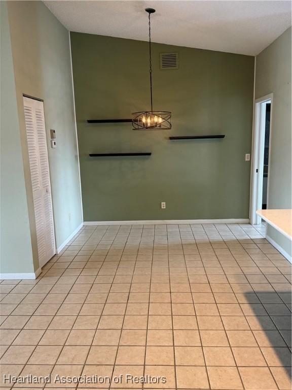 interior space with a notable chandelier, light tile patterned flooring, and high vaulted ceiling