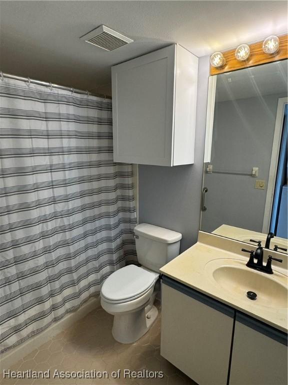 bathroom with tile patterned flooring, vanity, and toilet