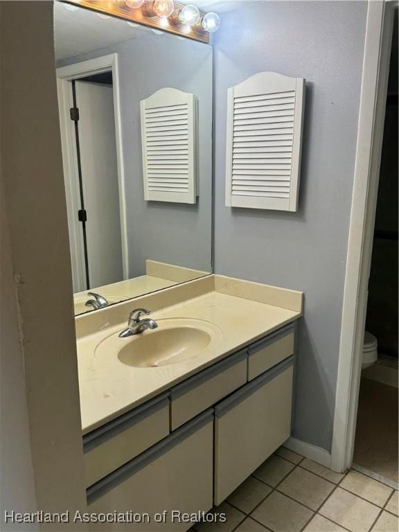 bathroom featuring tile patterned floors, vanity, and toilet