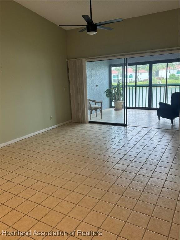 empty room with ceiling fan and light tile patterned floors