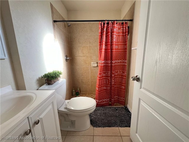 bathroom featuring toilet, vanity, tile patterned floors, and walk in shower