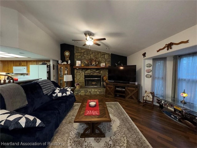 living room featuring ceiling fan, a fireplace, dark hardwood / wood-style floors, and vaulted ceiling