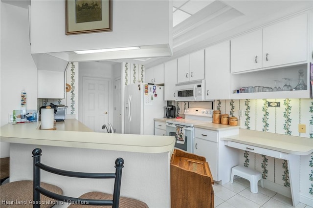 kitchen featuring white cabinets, white appliances, and kitchen peninsula