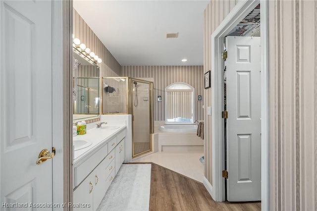 bathroom with hardwood / wood-style flooring, vanity, and separate shower and tub