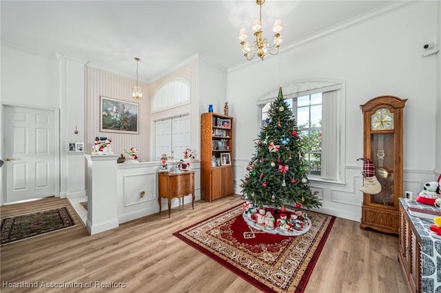 interior space featuring ornamental molding, light hardwood / wood-style floors, and an inviting chandelier