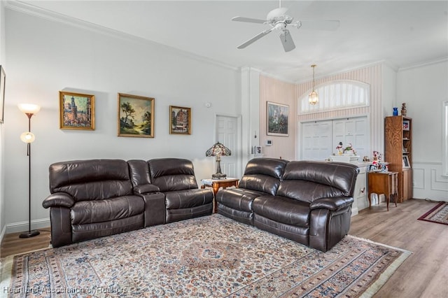 living room featuring light hardwood / wood-style floors, ceiling fan, and ornamental molding