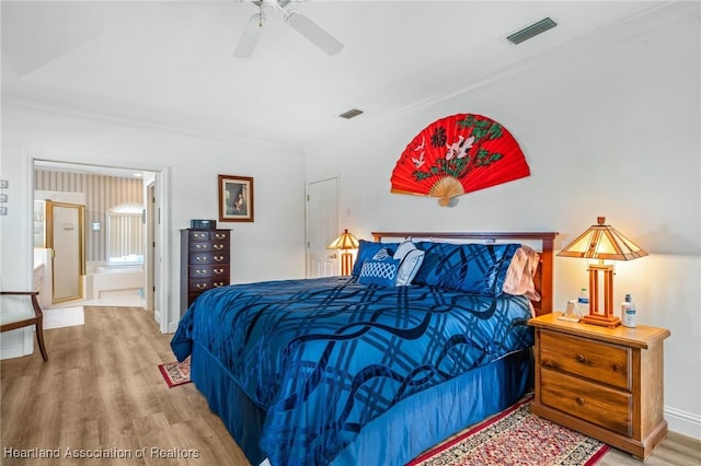 bedroom featuring hardwood / wood-style flooring, ceiling fan, and ensuite bath