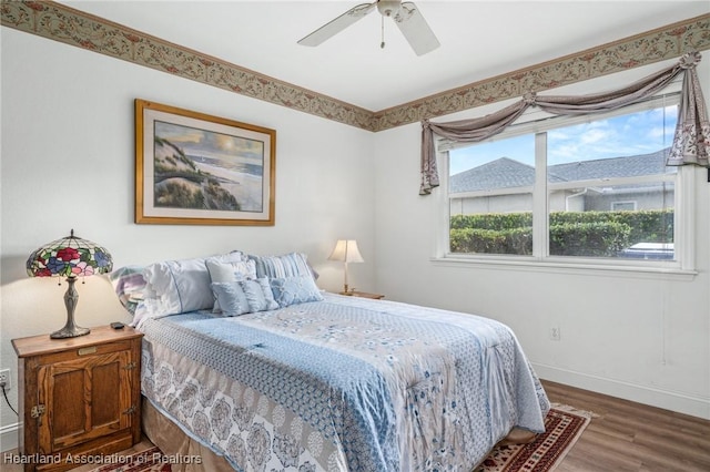 bedroom with multiple windows, ceiling fan, and hardwood / wood-style floors