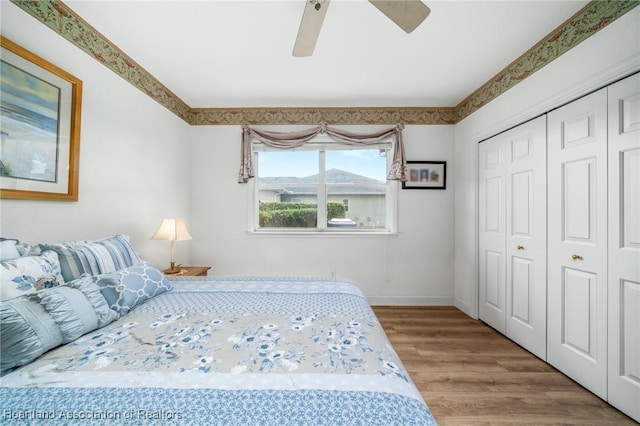 bedroom with ceiling fan, a closet, and wood-type flooring