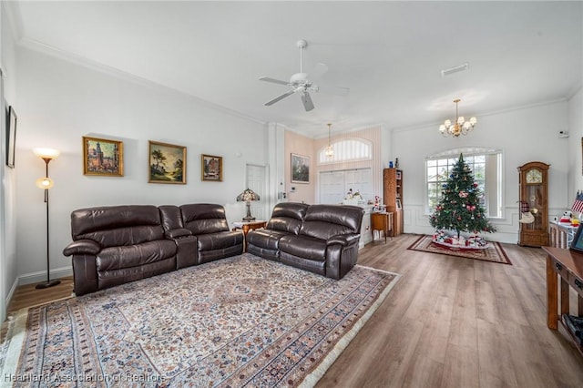 living room with hardwood / wood-style floors, ceiling fan with notable chandelier, and crown molding