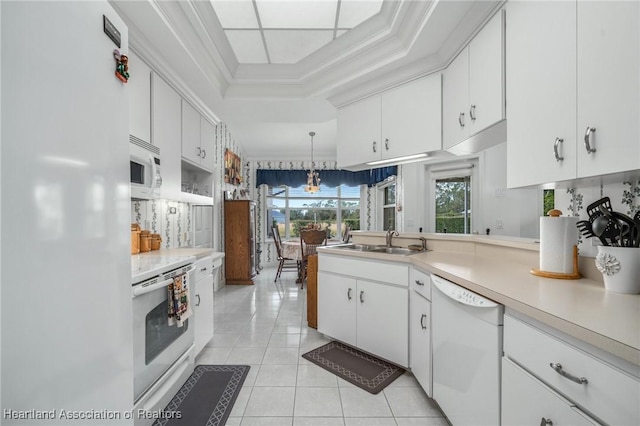 kitchen featuring white cabinetry, sink, pendant lighting, white appliances, and light tile patterned floors