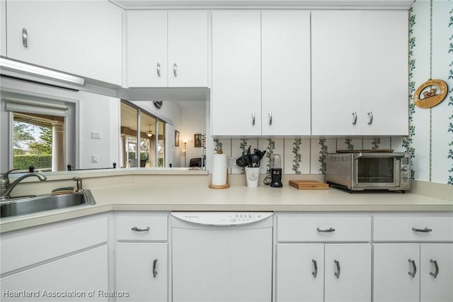 kitchen with dishwasher, white cabinetry, and sink