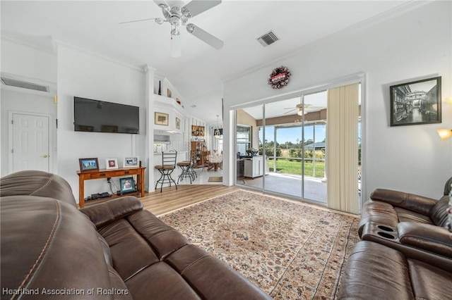 living room with ceiling fan, crown molding, vaulted ceiling, and hardwood / wood-style flooring