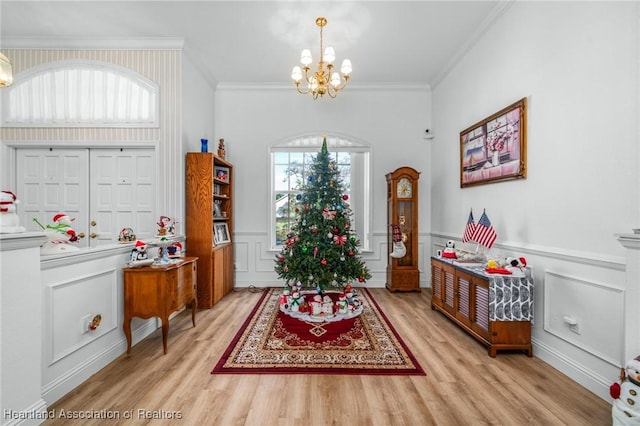 interior space featuring a chandelier, light hardwood / wood-style floors, and crown molding