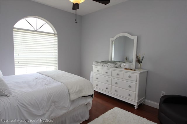 bedroom with dark hardwood / wood-style floors and ceiling fan