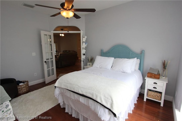 bedroom featuring ceiling fan, dark hardwood / wood-style floors, and french doors