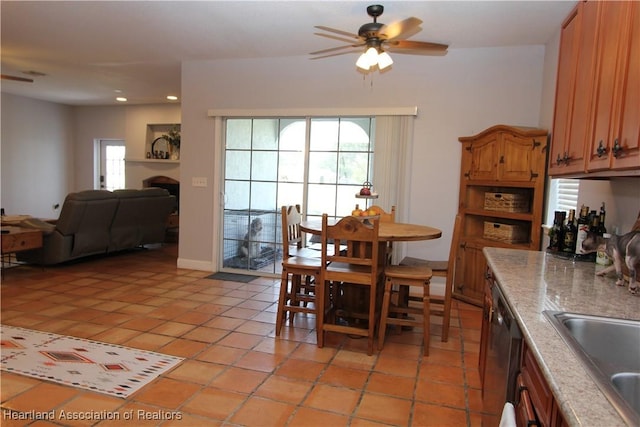 tiled dining space with ceiling fan and sink