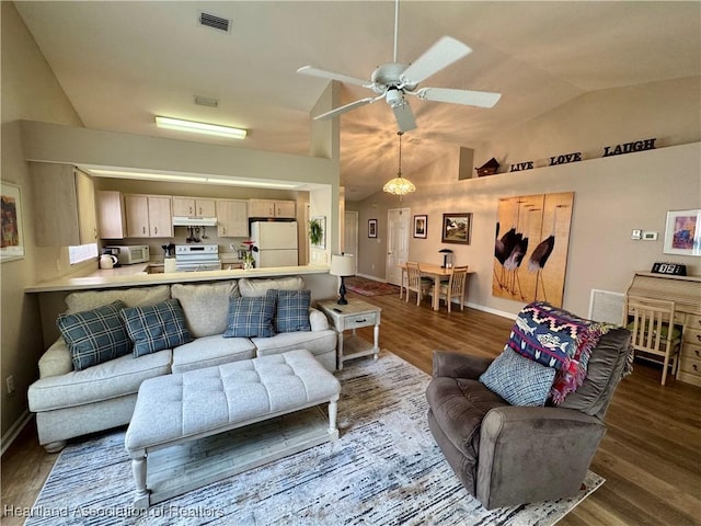 living area with ceiling fan, visible vents, vaulted ceiling, and wood finished floors