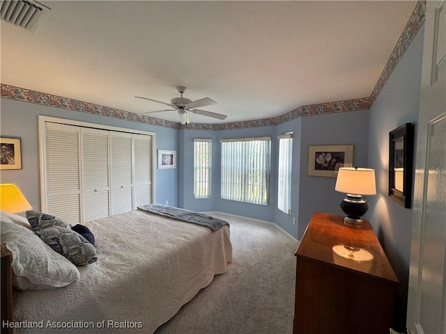 carpeted bedroom featuring a closet, visible vents, ceiling fan, and baseboards