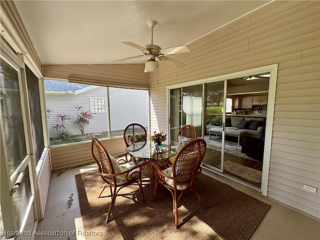 sunroom featuring lofted ceiling and a ceiling fan